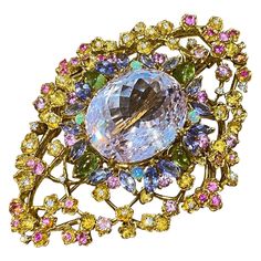 Kunzite and Multi-gems Diamond Pin / Brooch in 18k Yellow Gold Kunzite and Multi-gems Diamond Brooch features a large Oval-shaped Kunzite weighing 41.63 carats, accented by pastel colored Tanzanite, Peridots, and Diamonds set in 18k Yellow Gold. Total kunzite weight is 41.63 carats. Total diamond weight is 0.38 carats. Brooch measures 2.58 inches long and 1.85 inches wide. Brooch weighs 41.1 grams. Set in 18k Yellow Gold. Hallmarks: K18 BUY WITH CONFIDENCE Authenticity is guaranteed for every item we sell. Gold Hallmarks, Gem Diamonds, Diamond Brooch, Pin Brooch, High Boots, Brooch Pin, Knee High, North American, Gems