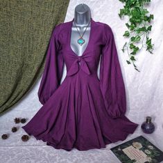 Modern witch dress; the Ophelia dress has long puff sleeves with a beautiful Cottagecore style. Gothic style purple lantern sleeve dress.  Handmade in the UK. Made to make you feel magick. 𝓣𝓱𝓮 𝓞𝓹𝓱𝓮𝓵𝓲𝓪 𝓓𝓻𝓮𝓼𝓼 ~o~ Witch Cottagecore Dress ~o~ She sits in the shade of a weeping willow on a balmy Summer afternoon, a well-worn tome spread across her lap. Lost in a world of literary fantasy, she is transported into a universe of magic ✨ It is made from Jersey stretch fabric to make it com Vintage Dresses For Fall Cosplay, Witchy Long Sleeve Cosplay Dress, Vintage Fall Cosplay Dresses, Witchy Long Sleeve Costume Dress, Vintage Fall Dresses With Lantern Sleeves, Vintage Lantern Sleeve Dress For Fall, Witchy Long Sleeve Mini Dress For Costume Party, Long Sleeve Fall Costume Dress, Vintage Long Sleeve Mini Dress For Costume Party