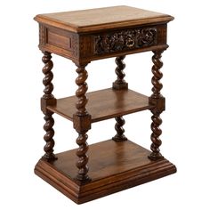 a wooden table with two tiered shelves on each side and an ornate carving at the top