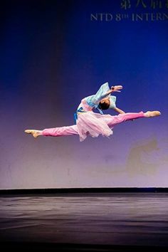 a person on a stage doing a trick with one leg in the air while another is standing behind her