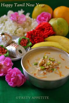 there is a bowl of soup next to some fruit and flowers on the table with words that say happy tammi new year