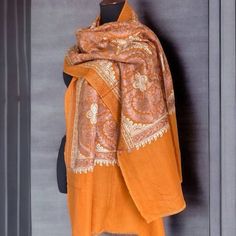 Exquisite fabric made of handmade shawl, harmonious masterpiece combining beauty and practicality. This stunning shawl, carefully crafted, has a saturated orange hue that radiates heat. The shawl is decorated with a charming floral pattern adorning the entire space of the shawl. Exquisite embroidery, decorated with bright shades of beige and bronze colors, adds elegance to the elegant design of nature. In addition to its exquisite beauty, this shawl is a wonderful gift that interweaves aesthetic Orange Shawl, Handmade Shawl, Beige Embroidery, Bohemian Scarf, Bohemian Scarves, Long Cape, Shades Of Beige, Pashmina Shawl, Bronze Color