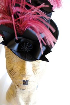 This gorgeous victorian mini top hat will compliment your victorian style gown in the most elegant way! It is covered with black satin with a discreet shine and embellished with black velvet ribbon along with black grosgrain ribbon, placed in an asymmetrical sculptural bow at one side front. A beautiful round velvet button and a glorious burgundy ostrich plum finish off this unique victorian inspired topper! Measurements : height 3.5 inches( 9 cm ),without the feather front to back 7.5 inches ( Black Velvet Ribbon, Mini Hats, Couture Hats, Mini Top Hat, Mini Top, Ostrich Feather, Colorful Feathers, Ostrich Feathers, Velvet Ribbon