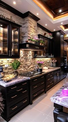 a kitchen with black cabinets and marble counter tops