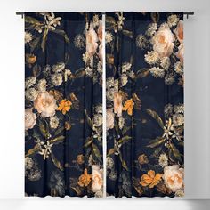 a black floral curtain with white and red flowers on the outside, in front of a gray wall