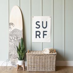 a surfboard is next to a wicker basket on the floor