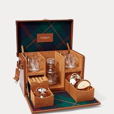 an open wooden box filled with glasses and other items