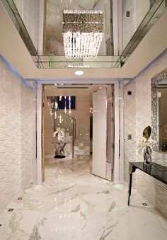 an elegant foyer with chandelier and marble flooring