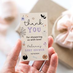 a person holding up a baby shower tag