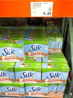 boxes of silk almond milk are stacked on a shelf in a grocery store for sale