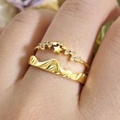 a close up of a person's hand wearing a gold ring