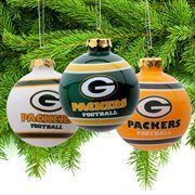 three green bay packers christmas ornaments hanging from a pine tree with white and orange balls