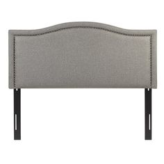 an upholstered headboard with black legs and nail accents on the top, in grey