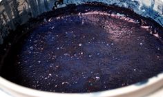 a pot filled with purple liquid sitting on top of a stove