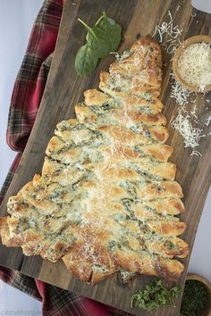 a christmas tree shaped pizza sitting on top of a wooden cutting board