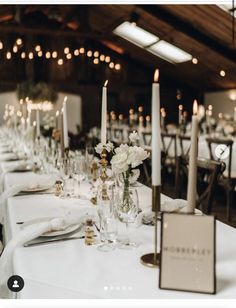 a long table is set with candles and place settings for the guests to sit at