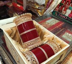 two red bracelets in a wooden box on display