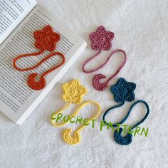 four crocheted hair ties laying next to an open book