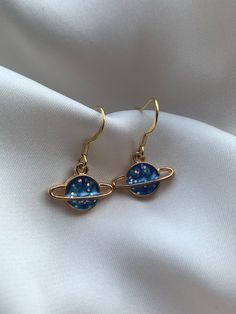 Size: 1.2x1.6x0.2cm  Weight: 30g (pendant only) Introducing the 'Blue Planet' earrings by J&K Jewellery. If you love all things space then these are the perfect earrings for you! Our earrings are all hypoallergenic that comes with a rubber back and each space pendants are made of high quality alloy. If you love all things planets, moon and stars then these are the one for you! These unique earrings will grasp everyone's eye. ↬ Hypoallergenic gold plated 304 stainless steel hooks ↬ All earrings c Celestial-style Pierced Rose Gold Jewelry, Celestial Style Pierced Rose Gold Jewelry, Celestial Rose Gold Pierced Jewelry, Celestial Drop Earrings Gift, Celestial Single Earring Jewelry Gift, Celestial Style Drop Earrings As Gift, Celestial Single Earring Jewelry For Gift, Celestial Style Hypoallergenic Drop Earrings, Rose Gold Celestial Earrings For Gift