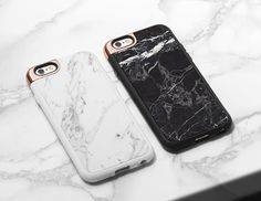 two iphone cases sitting on top of a white marble countertop next to each other