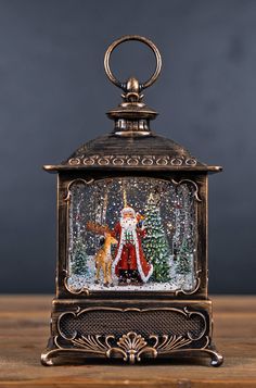 an old fashioned clock with a santa clause and reindeer on it's face, sitting on a wooden table