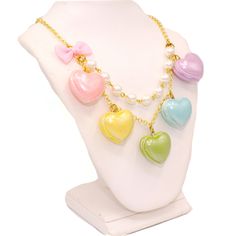 A cute and sweet statement necklace for Valentine's Day or lovecore season! This kawaii charm necklace includes Five heart shaped macaron ( macaroon ) pendants in pastel shades with a pearly finish and whipped cream center. Each necklace includes five 1" (2.5 cm) size charms hanging on a two-layered chain necklace with glass pearls on your choice of a 21" gold plated or silver plated chain. Accented with a baby pink fabric ribbon bow on one side. Necklace will be finished with a Fatally Feminine Kawaii Necklaces For Valentine's Day, Cute White Necklace With Heart Charm, Multicolor Heart-shaped Kawaii Jewelry, Sweet Multicolor Necklaces For Gift, Sweet Multicolor Necklace For Gift, Kawaii Multicolor Heart-shaped Jewelry, Sweet Multicolor Heart-shaped Jewelry, Sweet Heart-shaped Necklace For Valentine's Day, Cute Multicolor Charm Necklaces For Valentine's Day