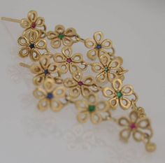 "14k solid gold earrings for woman. Gold long earrings, three dangle flowers with colorful gemstones set in each flower, red Ruby, blue Sapphire and green Tsavorite. Three small droplets dangle from the bottom of the flowers for a vibrant lively motion. The Emerald, Ruby and Sapphire gemstone are noticeable yet barely seen, to preserve the gentle look of these yellow gold earrings. The gold flowers are moving and dancing about freely with your head motions, giving a sense of liveliness and a joi Yellow Gold Multi-stone Party Earrings, Party Multi-stone Yellow Gold Earrings, Elegant Multicolor Flower-shaped Jewelry, Elegant Multicolor Flower-shaped Earrings, Elegant Multicolor Flower Earrings For Wedding, Elegant Multicolor Flower Earrings, Gold Long Earrings, Red Ruby Earrings, Ruby And Sapphire