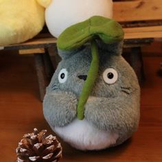 a stuffed animal sitting next to a pine cone