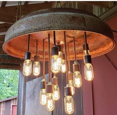 a chandelier made out of an old drum with light bulbs hanging from it