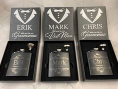 three personalized flasks and two hip flasks in black boxes on a marble floor