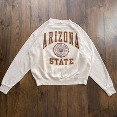 Vintage 1990s Arizona State University College Varsity Crest Crewneck Sweatshirt / made in USA / size XL Pit to Pit:   25" Top of Shoulder to Bottom Hem:   25" Collar to Bottom of Sleeve:   32" Please check the measurements before purchasing  ---------------------------------- 🛒 Why Vintage? Vintage clothing is an environmentally sustainable way to shop for cool, unique, and rare clothing. Vintage clothing is typically higher quality than modern fast fashion manufacturing. Material from the 80s Vintage Graphic Print Top For Campus, Vintage Crew Neck Tops For Campus, Retro Crew Neck Tops For Campus, Oversized Vintage T-shirt, Oversized Vintage Sweater With Letter Print, Vintage College Apparel, 90s Graphic Print College Sweatshirt, Vintage College Sweatshirt With Logo Print, Vintage College Sweatshirts