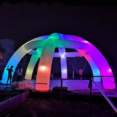 people are standing under an inflatable structure at night