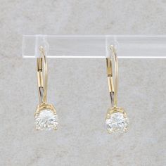 This pair of earrings are 14k yellow gold and they have two round brilliant diamonds that are prong set. These diamonds measure 1.00cttw, with one having a color and clarity of L/SI2 and the other having a color and clarity of M/SI2. The earrings measure 5.0mm wide and 14.0 mm tall. They weigh 1.23 grams. Condition: Pre-Owned *All items are thoroughly inspected for quality assurance purposes Gold Hoop Earrings With Single Diamond, Classic Single Diamond Huggie Earrings, Elegant Yellow Gold Hoop Earrings With Diamond, Classic 14k Gold Hoop Earrings With Single Diamond, Classic Yellow Gold Hoop Earrings With Single Diamond, Classic Gold Hoop Earrings With Brilliant Cut, Classic Round Hoop Earrings With Single Diamond, Classic Yellow Gold Diamond Drop Earrings, Elegant 14k Gold Hoop Earrings With Single Diamond