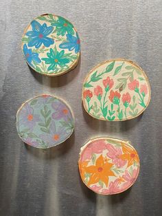 four painted plates sitting on top of a table