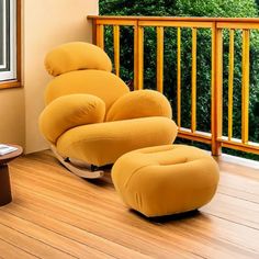 a yellow chair and ottoman on a wooden floor in front of a balcony with trees