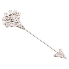 An Art Deco white gold, platinum, and diamond brooch, comprising twenty-seven old cut diamonds, set in platinum, and backed 18 karat white gold, with a white gold pin. This striking brooch is formed as an arrow. Arrow jabot pins were at the height of fashion in the Art Deco era and judging by the Belle Epoque influences to the design, I would judge this as being an early example. The elegantly pointed arrowhead is set with 6 sparkling old cut diamonds, which are round in shape, and surrounded by millegrain edging. The pin is in white gold and leads to the diamond encrusted fletching of the arrow. 14 further old cut diamonds make up the main portion of the fletching, which has been designed in a fan shape, with geometric openwork details which make this brooch all the more striking when wor Classic White Diamond Brooches, Platinum White Gold Fine Jewelry Brooch, Platinum Brooches With Single Cut Diamonds In White Gold, White Gold Brooches With Single Cut Diamonds In Platinum, Art Deco Platinum Brooches In White Gold, Art Deco White Gold Brooch In Platinum, Art Deco White Gold Platinum Brooches, Diamond Brooches In Brilliant Cut White Gold, White Gold Diamond Brooch With Brilliant Cut