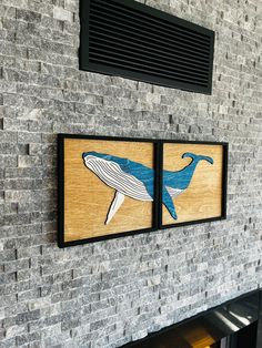 two paintings on the wall of a brick fireplace