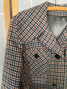 1970’s Juli de aroma houndstooth coat with a blue belt. Belt is made of a faux leather material that, being 50 years old, is now a little sticky to the touch and flakes off in the hand. Missing buttons 2 and 4 and the left pocket buttons. Bust: 40”Shoulder to hem: 41” Retro Long Sleeve Houndstooth Blazer, Retro Belted Fall Outerwear, Retro Belted Outerwear For Fall, Retro Formal Fall Outerwear, Orange Wool Outerwear For Fall, Retro Winter Outerwear For Office, Retro Winter Office Outerwear, Retro Houndstooth Blazer For Winter, Retro Houndstooth Winter Blazer