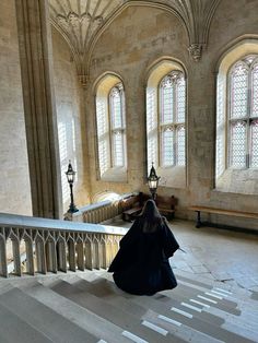 a woman sitting on the stairs in an old building