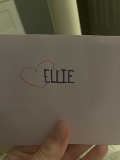 someone holding up a piece of paper with the word ellie written on it