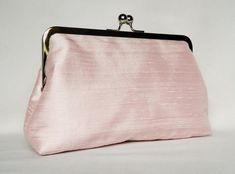 a pink purse with a black handle on a white background, it looks like something from the 1950s