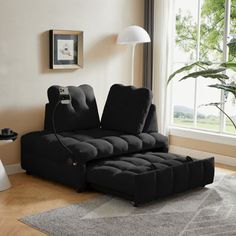 a living room scene with focus on the futon bed and floor lamp in the corner