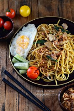 a plate with noodles, vegetables and eggs on it