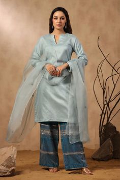 Sky blue straight chanderi kurta. Comes with dark blue hand embroidered chanderi pant and butti embroidered dupatta.
Components: 3
Pattern: Hand Embroidered
Type Of Work: Sequins, Pearls, Cutdana
Neckline: Notched
Sleeve Type: Full
Fabric: Kurta and Pant: Chanderi, Dupatta: Organza
Color: Blue
Other Details: 
Attached lining
Approximate product weight: 0.5-1 kg
Occasion: Puja - Aza Fashions Traditional Silk Pants For Diwali, Traditional Silk Pants For Eid, Traditional Chanderi Pants With Dabka Work, Traditional Chanderi Pants For Eid, Blue Cotton Sharara With Sheer Dupatta, Silk Pants With Traditional Drape For Eid, Dabka Embellished Tussar Silk Sharara, Eid Chanderi Pants With Dupatta, Eid Palazzo Set With Straight Pants