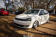 a white car parked in front of some trees