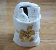 a white towel wrapped in gold ribbon with personal care products inside it on a wooden floor