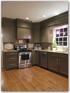 a kitchen with wood floors and stainless steel appliances