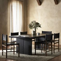 a dining room table with chairs and a potted plant