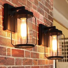 two light fixtures mounted to the side of a brick wall