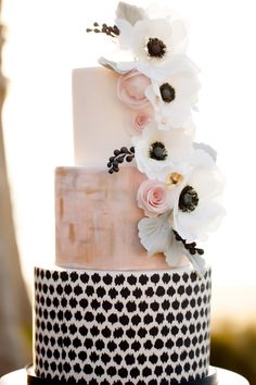 a white and black cake with flowers on top